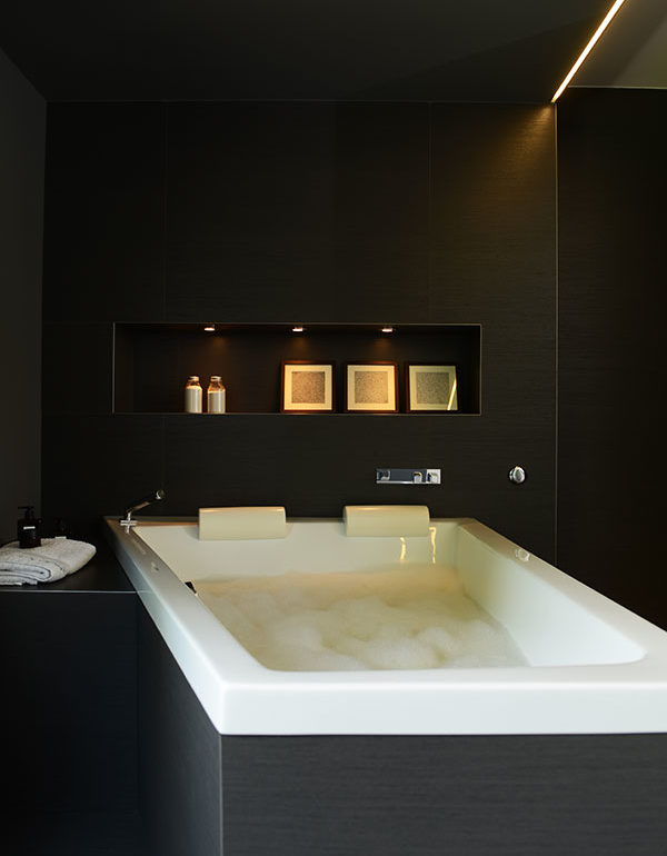 Bad in schwarzen Fliesen.